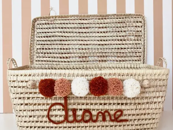 0e36025d881218eb580f0328b006c4f3904a87f14ab26808f0f538aff6218a93-1.webp Personalized Palm Leaf Chest with Tassels – Handwoven Moroccan Storage Trunk