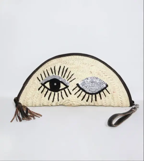20fe87f32b6ef2a8c1946929902881c6e606a5e384776956c9bc687812ef2bfe-1.webp Eyes Clutch – Handwoven Palm Leaf Bag with Embroidered Eyes Design