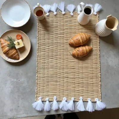 5aff86e6-ded2-42ad-893a-2b997a7e0ee9.webp Hand-Woven Moroccan Tassel Placemats – Rattan & Cotton Dining Decor (15.5″ × 12″)