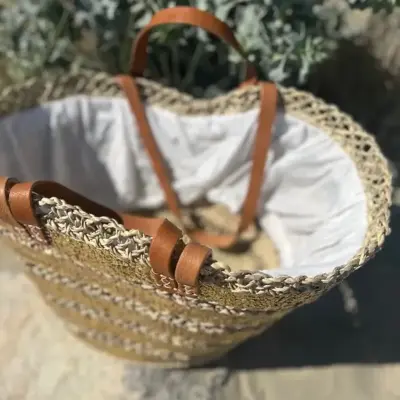638d3b58f89b6e27b09ceef583446bc34a54356d6562308b9a4056894fb1d08e-1.webp Sequin Basket – Handwoven Doum Palm Fiber Tote with Leather Handles & Drawstring Closure