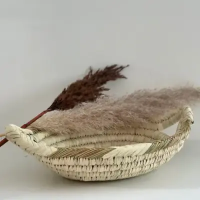 97050cafbbe96d92ac32984bc61582e61a27695a2e246e517708557eaade6298-1.webp Handwoven Oval Basket – Natural Palm Leaf Storage & Serving Tray