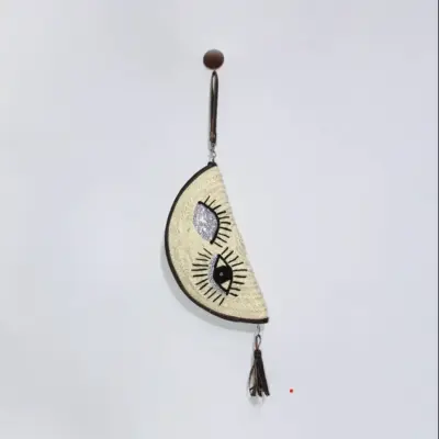 9a9dbe881f1e980aaee4da4b8c769bdf1c7a160ec8fd1aa78b8f451c9587b217-1.webp Eyes Clutch – Handwoven Palm Leaf Bag with Embroidered Eyes Design