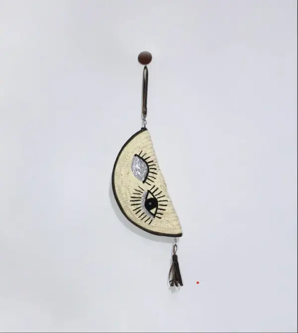 9a9dbe881f1e980aaee4da4b8c769bdf1c7a160ec8fd1aa78b8f451c9587b217-1.webp Eyes Clutch – Handwoven Palm Leaf Bag with Embroidered Eyes Design