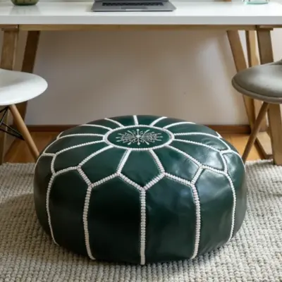 Round-Moroccan-Leather-Pouf-Green-4-e1733396210425-768x698-1.webp Handcrafted Green Leather Pouf – 21″ Moroccan Round Ottoman with White Stitching