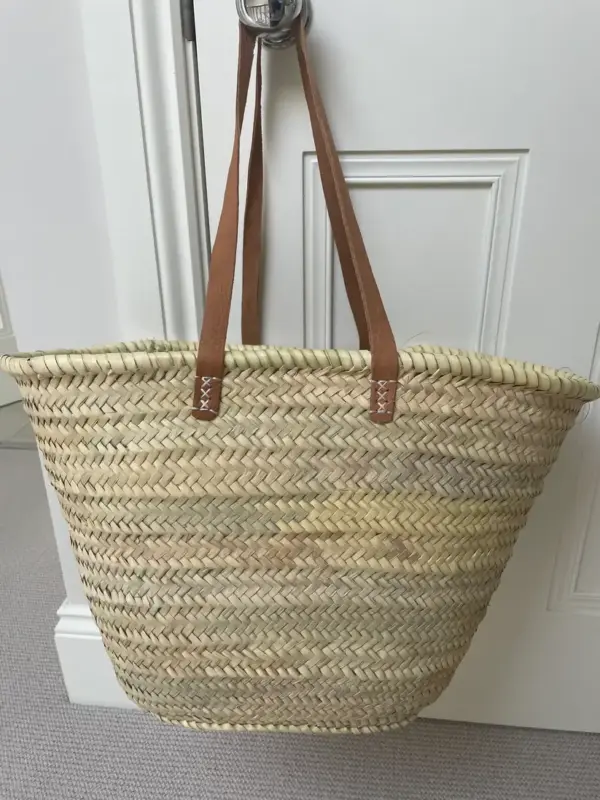 e6b2fe1d3f7d8fffc26ea1350f0d397dbe7e3b1b1dada84decb1da6fc07914ab-1.webp Emma French Style Basket – Handwoven Palm Leaf Tote with Leather Handles